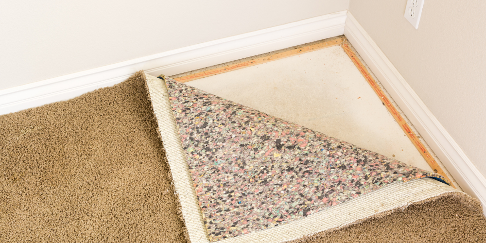 A carpet that is pulled up in the corner of a room.